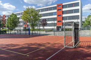 Blick über das Sportfeld auf das Schulgebäude